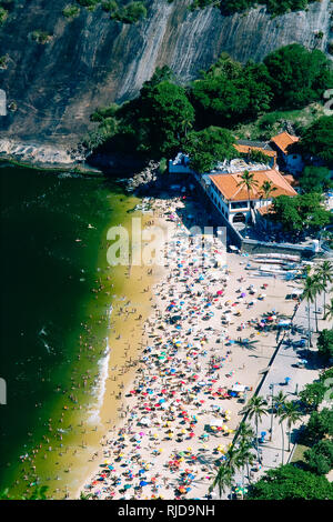 I residenti locali e turisti relax a Praia Vermelha beach contro uno sfondo di Sugarloaf montagna, una delle più popolari attrazioni turistiche in th Foto Stock