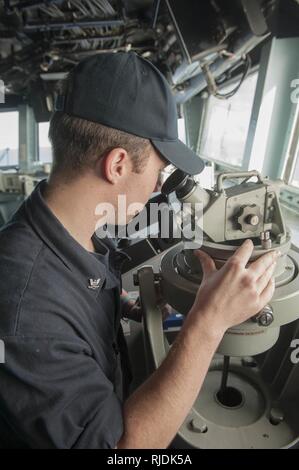 Oceano Pacifico (GEN. 21, 2018) di Boatswain Mate 3° di classe Daniel Lynch, un nativo di Detroit, legge la nave il cuscinetto utilizzando un alidada telescopico sul ponte a bordo dell'assalto anfibio nave USS America (LHA 6) America, parte dell'America anfibio gruppo pronto, con avviato xv Marine Expeditionary Unit, è di ritorno da 7 mesi di distribuzione per gli Stati Uniti 3a, 5 e 7 settori della flotta delle operazioni. Foto Stock