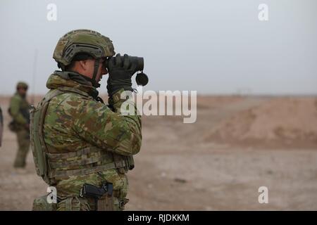 Un australiano SOLDIER Guarda la gamma in preparazione per .calibro 50 mitragliatrice e Mark 19 lanciagranate familiarizzazione fire, con i membri di Qwat Khasa battaglione, esercito iracheno, presso la gamma Besmaya complessa, Iraq, Gennaio 24, 2018. La formazione a costruire la capacità del partner sites è parte integrante della Combined Joint Task Force - Funzionamento inerenti risolvere la coalizione globale impegno di addestrare le forze di sicurezza irachene personale per proteggere e stabilizzare il loro paese e scoraggiare la ricomparsa di Iside. Foto Stock