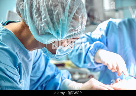 Mento di aumento di riduzione doppio mento distacco chirurgia plastica operazione cosmetica concetto. Chirurgia mento close-up con la ferita aperta. Foto Stock