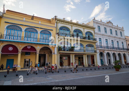 Da parete a parete spagnolo edifici in stile coloniale con gente seduta al di fuori di un Cafè presso la Old Town Square Plaza Vieja in Havana Cuba Foto Stock