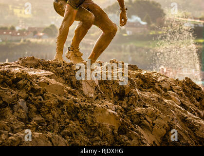 Trail Running atleta attraversando la pozzanghera sporca in un corridore di fango. Foto Stock