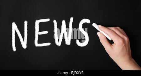Mano femmina iscritto notizie sulla lavagna Foto Stock