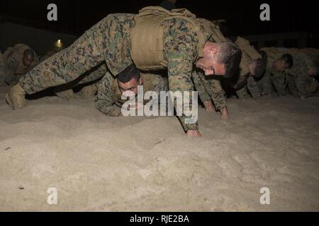 Stati Uniti Marines costruire un ponte durante le loro Marine Corps Arti Marziali Programma del corso in corrispondenza del Mar Beach su Camp Pendleton, California, Gennaio 19, 2018. Con oltre un centinaio di partecipanti, il corso è stato offerto di più unità in un tentativo di raggiungere marines che altrimenti non avrebbero accesso a un istruttore MCMAP. Foto Stock