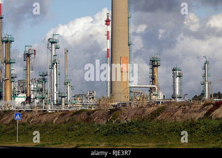 Parte di una grande raffineria di petrolio con il rosso e bianco camino in un pomeriggio nuvoloso Foto Stock