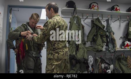 (Da sinistra) U.S. Air Force Capt. James Broncheau, tredicesima Fighter Squadron F-16 Fighting Falcon pilota, rimuove il volo con ingranaggio guida dalla U.S. Navy Petty Officer 2a classe Julio Gonzalez, un attacco elettronico Squadron (VAQ) 134 equipaggi equipmentman sopravvivenza, dopo un EA-18G Growler familiarizzazione volo a Misawa combatté Air Base, Giappone, Gennaio 18, 2018. VAQ-134, di stanza al di fuori del Naval Air Station Whidbey Island, Washington, era a Misawa combatté dal settembre per una routine di distribuzione di rotazione all'interno della regione e sono volato con F-16s su una base settimanale. Foto Stock