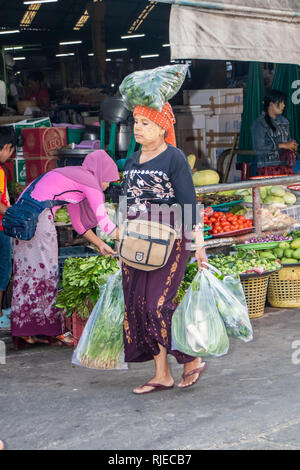 Mae Sot, Tailandia - 3 Febbraio 2019: la donna che porta il suo shopping home dal mercato mattutino. Ci sono dei gruppi etnici nell'abitato. Foto Stock