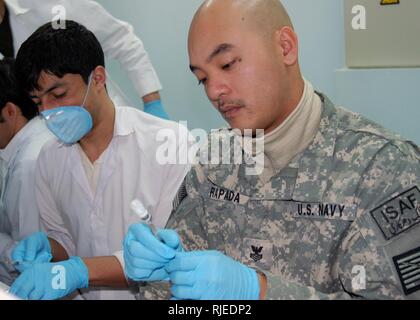 Rusty Rapada, un Mentor di radiologia presso l esercito nazionale afgano il 209th Corps Camp Shaheen Army Medical Hospital, Afghanistan, dà una mano a Afghan fornitori di assistenza sanitaria dal disegno immunizzazioni meningococcica per circa 400 ANA basic tirocinanti, Dic 31, 2009. Rapada distribuito da Yokosuka, Giappone, come parte del combinato per la sicurezza nella fase di transizione medico Command-Afghanistan Embedded Formazione del team di quest'anno per aiutare lo sviluppo e la formazione delle controparti afghane. Foto Stock