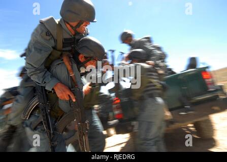 KABUL, Afghanistan (19 aprile 2010) - una nazionale afghano di ordine civile di polizia (ANCOP), ufficiale reca un "ferito" ufficiale per un altro veicolo come essi pratica azione di emergenza trapani convoglio durante le operazioni di formazione presso un impianto di Kabul. I funzionari di polizia del elite force ricevuto formazione convoglio, avvistato le loro armi e abilità di tiro ha ricevuto la formazione come si preparano per le operazioni in Afghanistan. Foto Stock