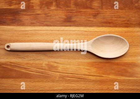 Il cucchiaio di legno sul bordo di taglio Foto Stock
