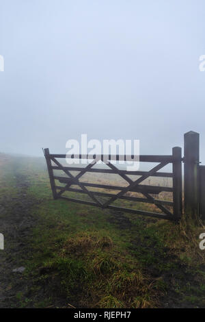 La parte di legno aperto fattoria che conduce a campo visto su un inverni nebbioso giorno in Lancashire, Inghilterra Foto Stock