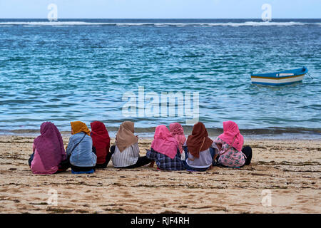 Le donne musulmane in velo seduto su Pandawa Beach, Bali, Indonesia Foto Stock
