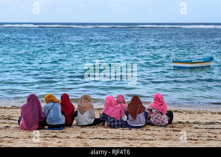 Le donne musulmane in velo seduto su Pandawa Beach, Bali, Indonesia Foto Stock