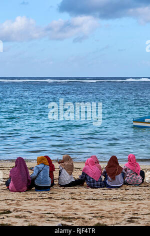 Le donne musulmane in velo seduto su Pandawa Beach, Bali, Indonesia Foto Stock