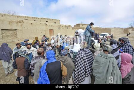 Afghan Polizia Locale distribuire coperte, sciarpe e altre forme di assistenza umanitaria fornisce come coperte, sciarpe, forniture di cottura e copie del Corano per gli abitanti di un villaggio in Walan area di Rabat, provincia di Zabul, gen. 16. ALP è una struttura difensiva, orientata alla comunità la forza che porta la sicurezza e la stabilità in aree rurali dell'Afghanistan. Foto Stock