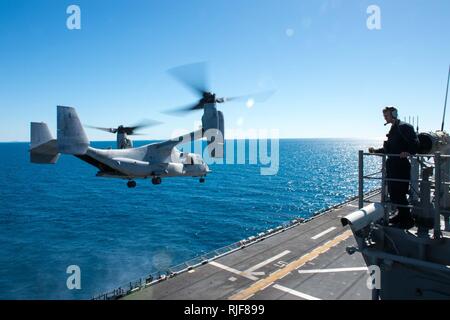 CORAL SEA (20 luglio 2017) un marinaio osserva una MV-22B Osprey assegnato al "draghi" del mezzo marino Tiltrotor Squadron (VMM) 265 (rinforzato) decollo dal ponte di volo dell'assalto anfibio nave USS Bonhomme Richard (LHD 6) durante il talismano di Saber 17. Talismano Saber è una biennale degli STATI UNITI - Australia esercizio bilaterale tenutosi al largo della costa australiana intende conseguire l'interoperabilità e rafforzare gli Stati Uniti-Australia alliance. Foto Stock