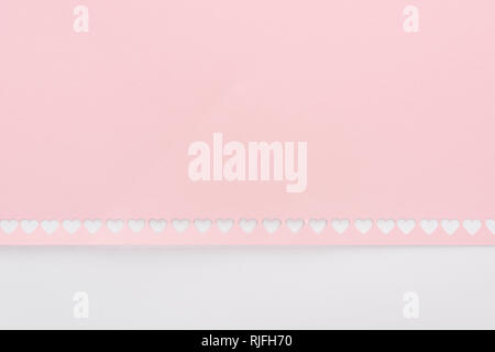 Sfondo di tagliare fuori i cuori in fila sulla carta rosa isolato su bianco Foto Stock