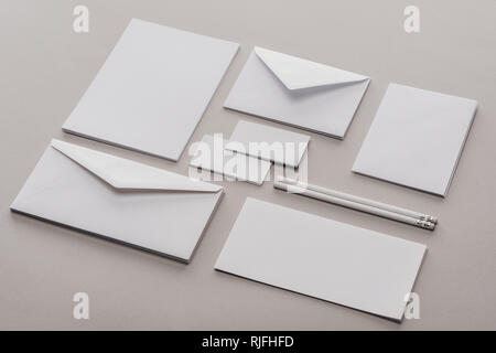 Lay piatto con buste, cartoline, fogli di carta e pennarelli su sfondo grigio Foto Stock