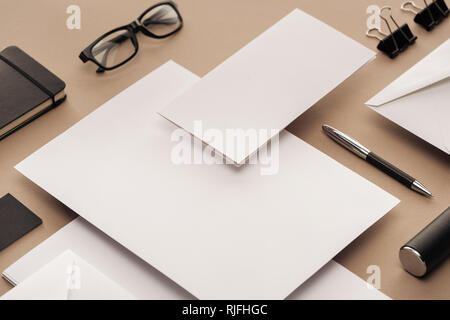 Lay piatto con gli occhiali, penna, notebook, custodia, clip di carta, buste e fogli di carta Foto Stock