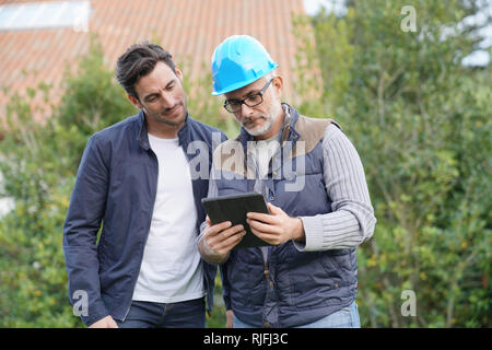Builder passando attraverso i piani esterni con il proprietario Foto Stock
