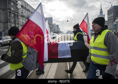 Varsavia, Polonia. 6 febbraio 2019. Gli agricoltori polacchi sono visto che trasportano una bara trattenendo le bandiere durante la protesta.Migliaia di agricoltori provenienti da tutta la Polonia in scena una protesta al di fuori del palazzo presidenziale a Varsavia, chiedendo la restituzione di varie compensazioni, il controllo e le restrizioni sulle importazioni di prodotti agricoli nonché un aumento dei prezzi di acquisto, la manifestazione si è tenuta dal gruppo Agrounia ed erano stati fatturati dagli agricoltori come ''Siege di Varsavia.'' Credito: ZUMA Press, Inc./Alamy Live News Foto Stock