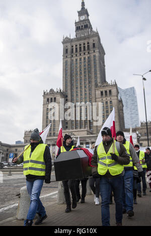 Varsavia, Polonia. 6 febbraio 2019. Gli agricoltori polacchi sono visto che trasportano una bara trattenendo le bandiere durante la protesta.Migliaia di agricoltori provenienti da tutta la Polonia in scena una protesta al di fuori del palazzo presidenziale a Varsavia, chiedendo la restituzione di varie compensazioni, il controllo e le restrizioni sulle importazioni di prodotti agricoli nonché un aumento dei prezzi di acquisto, la manifestazione si è tenuta dal gruppo Agrounia ed erano stati fatturati dagli agricoltori come ''Siege di Varsavia.'' Credito: ZUMA Press, Inc./Alamy Live News Foto Stock