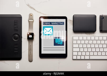 Lay piatto con vari dispositivi wireless e marketing e-mail illustrazione su marmo bianco superficie Foto Stock