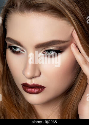 Bella donna redhead toccando il suo volto Foto Stock