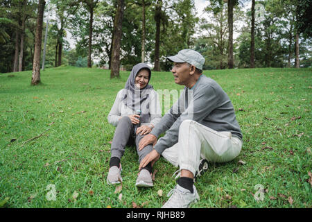 Vecchia coppia avendo alcuni massaggi seduti nel parco Foto Stock