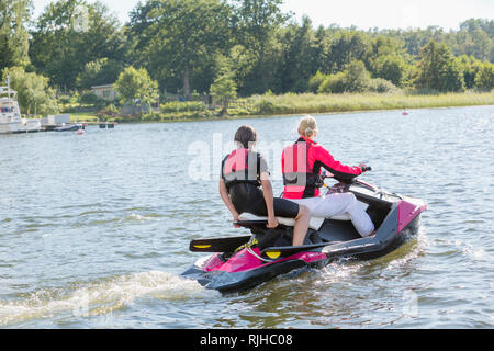 Madre e figlio adolescente su jet ski Foto Stock