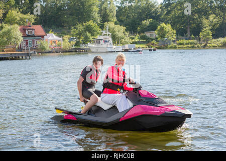 Madre e figlio adolescente su jet ski Foto Stock