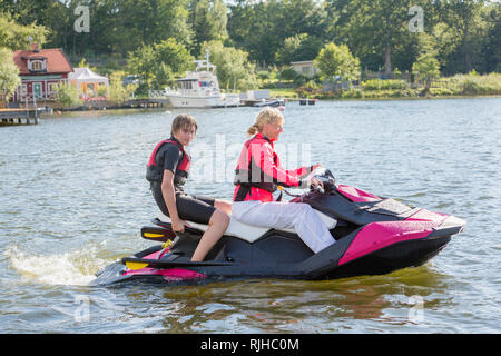 Madre e figlio adolescente su jet ski Foto Stock