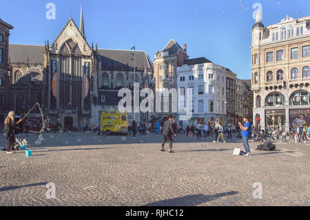 Amsterdam, Paesi Bassi, ottobre 10, 2018: Bella bolle di sapone perfomance presso la piazza con la gente a piedi e guardare circondato dalla medioevale Foto Stock