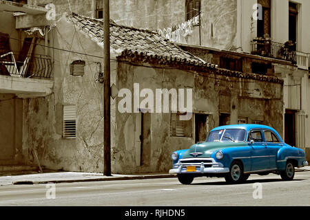 Blue vintage auto sulla strada Avana con vecchie case fatiscenti, seppia immagine in stile Foto Stock