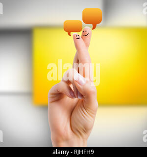 Due dita con le faccine che simboleggiano le persone in chat con ciascun altro Foto Stock