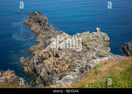 Sperone di roccia che mostra limpidezza del mare sulla costa di Alderney vicino a Roselle punto. Foto Stock