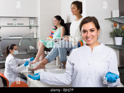 Ritratto di felice per la ricostruzione professionale delle unghie master al posto di lavoro invitante al salon Foto Stock