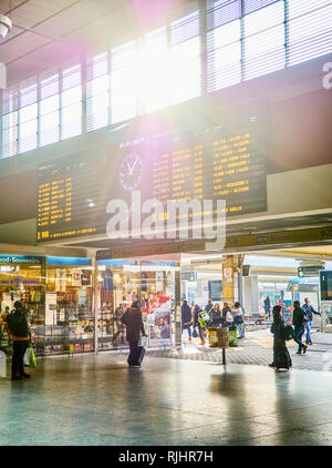 Torino, Italia - Gennaio 1, 2019. I viaggiatori sotto un digital display orario in una sala della stazione ferroviaria di Porta Nuova. Torino Piemonte, Italia. Foto Stock