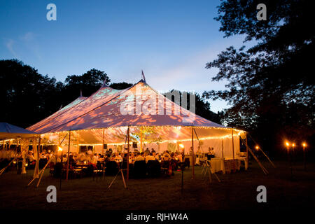 Tenda di nozze di notte - evento speciale tenda illuminato dall'interno con blu scuro notte cielo e alberi Foto Stock