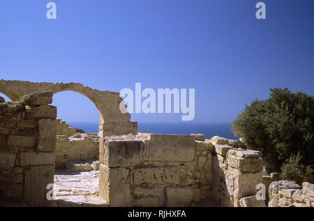 Palazzo del vescovo rimane, antica Kourion, Episkopi, Distretto di Limassol, Cipro: arco di pietra contro il blu del Mediterraneo Foto Stock