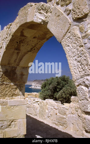 Palazzo del vescovo rimane, antica Kourion, Episkopi, Distretto di Limassol, Cipro: arco di pietra contro il blu del Mediterraneo Foto Stock