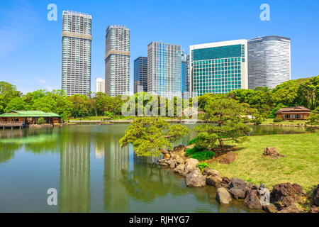 Giardini Hamarikyu con edifici riflettono sul laghetto del quartiere Shiodome-Shimbashi sullo sfondo. Hama Rikyu è un bellissimo ed ampio giardino paesaggistico in Foto Stock
