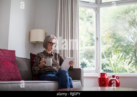Coppia femmina adulta utilizzando una tavoletta digitale Foto Stock