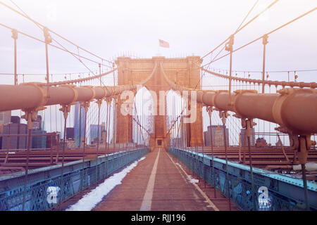 Passaggio pedonale del ponte di Brooklyn con bandiera americana sulla torre, New York City, Stati Uniti d'America Foto Stock