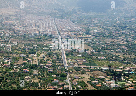 Vista aerea della città storica di Cinisi nel quartiere Palermo di Sicilia. Circondata da terreni coltivati e visto su una soleggiata mattina d'estate. Foto Stock