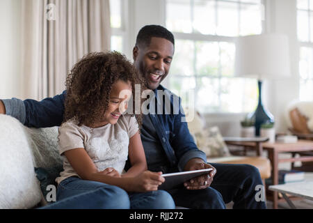 African American padre e figlia con tavoletta digitale insieme Foto Stock