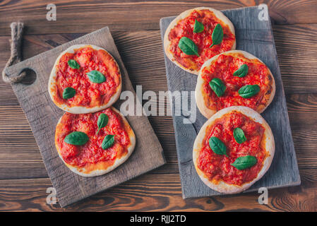 Mini Pizza Margherita con formaggio rosso sul pannello di legno Foto Stock