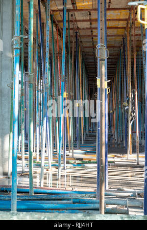 Puntoni metallici nella struttura di edificio in costruzione. Strumenti di costruzione Foto Stock