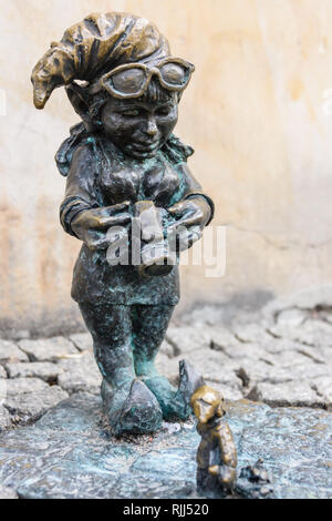 Uno degli gnomi in ottone (krasnale, krasnoludki), un fotografo di fotografare una miniatura di Gnome, di Breslavia, Wroklaw, Polonia Foto Stock