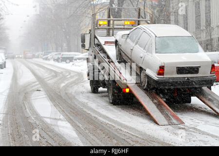 Auto rompersi e il traino a neve street Foto Stock